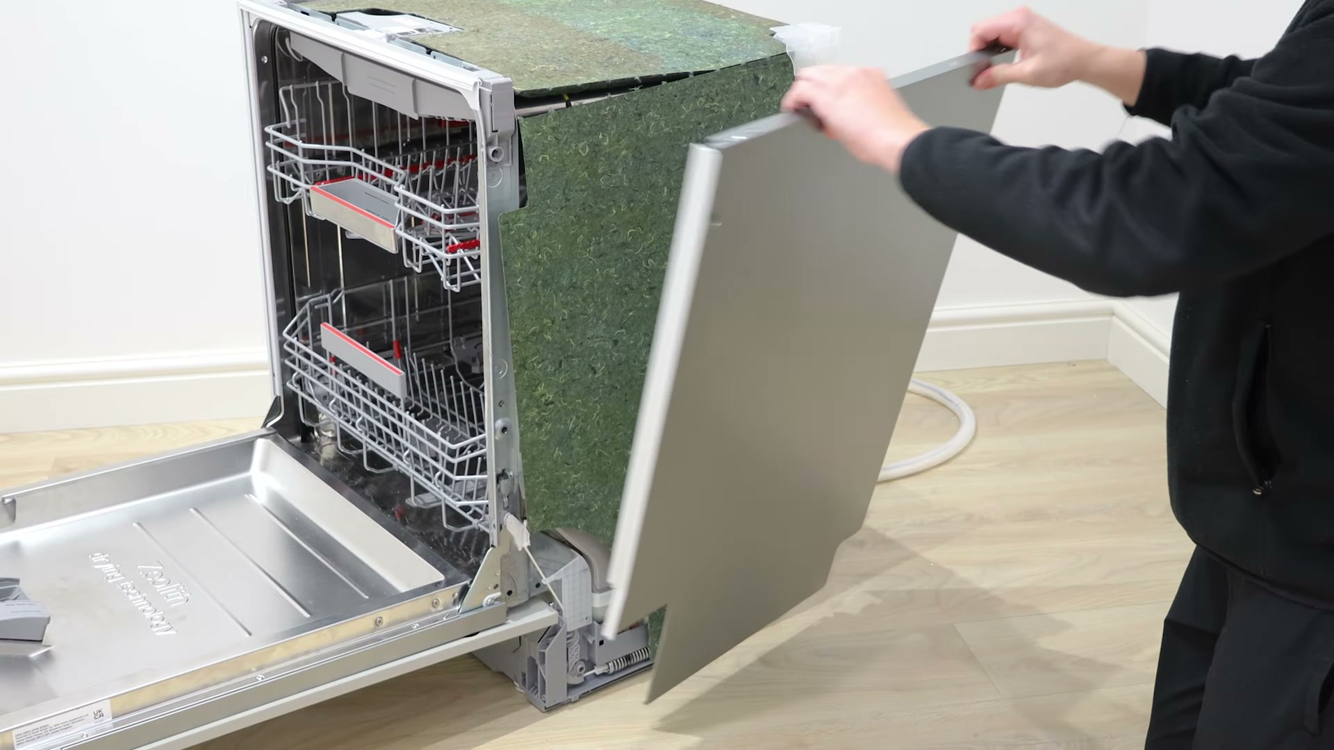 Removing the right side panel from a Bosch dishwasher to access the actuator