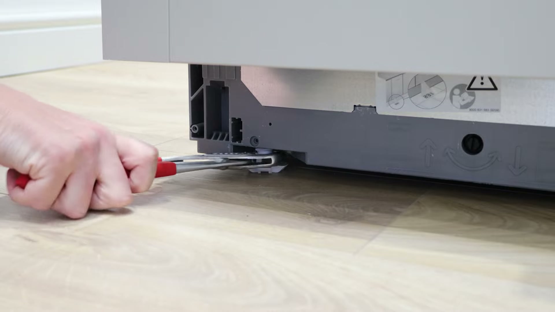 Levelling the front feet of a Bosch dishwasher with water pump pliers