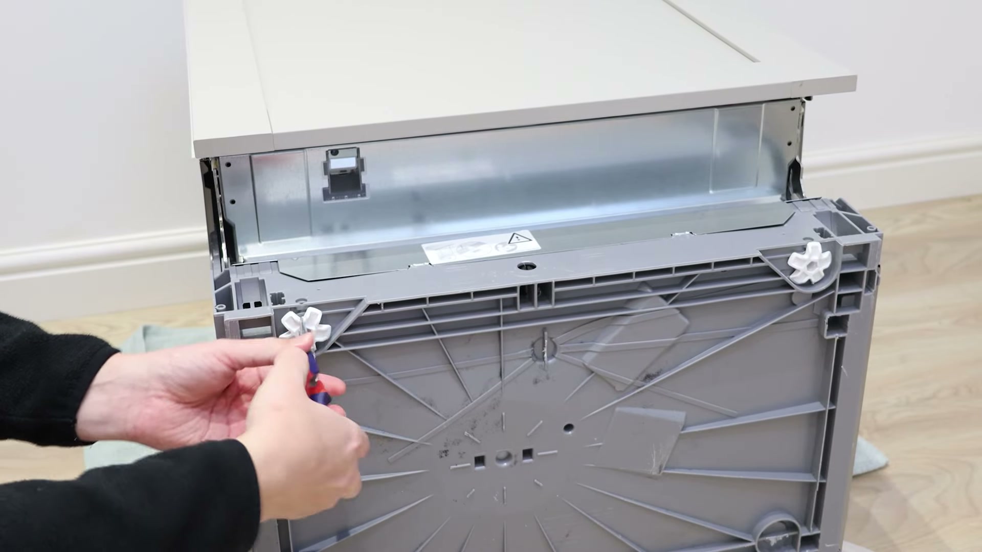 Using pliers to remove an old adjustable foot from a Bosch dishwasher