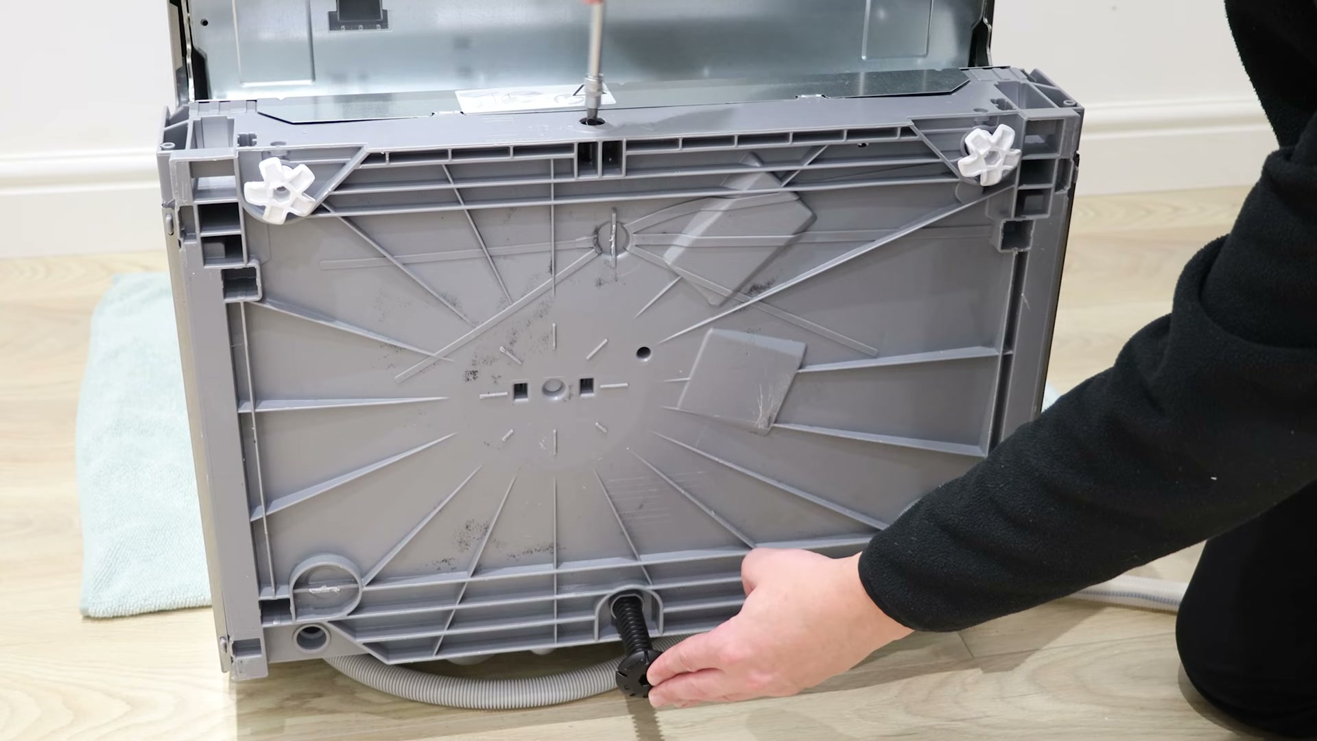 Fitting the new adjustable rear foot into the base of a Bosch dishwasher