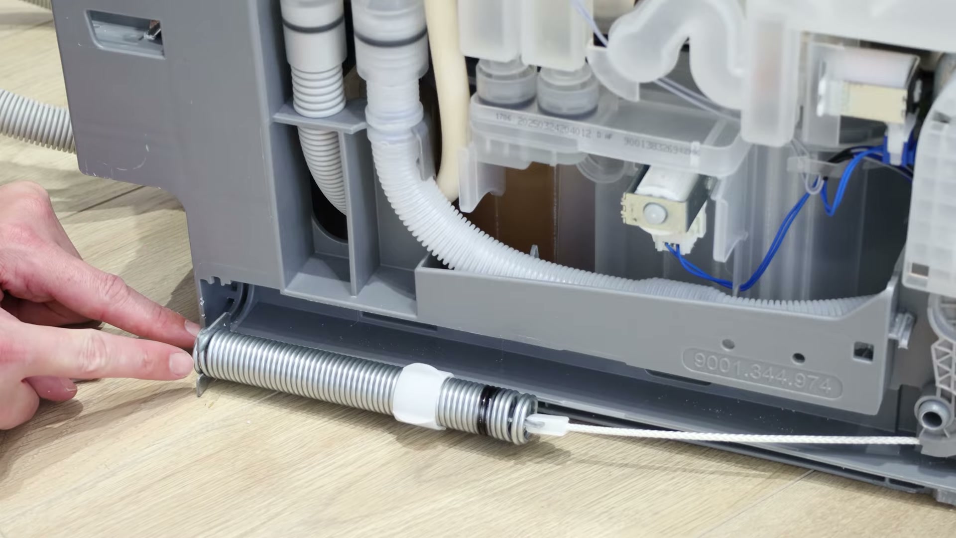 Door hinge spring connected to the new rope string on a Bosch dishwasher