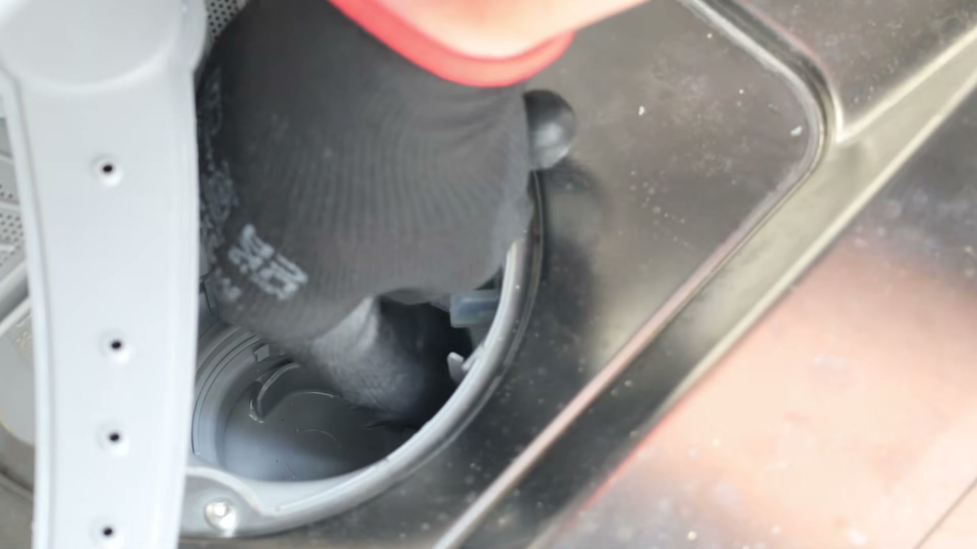 Pressing the new lid cover into place inside the drain pump