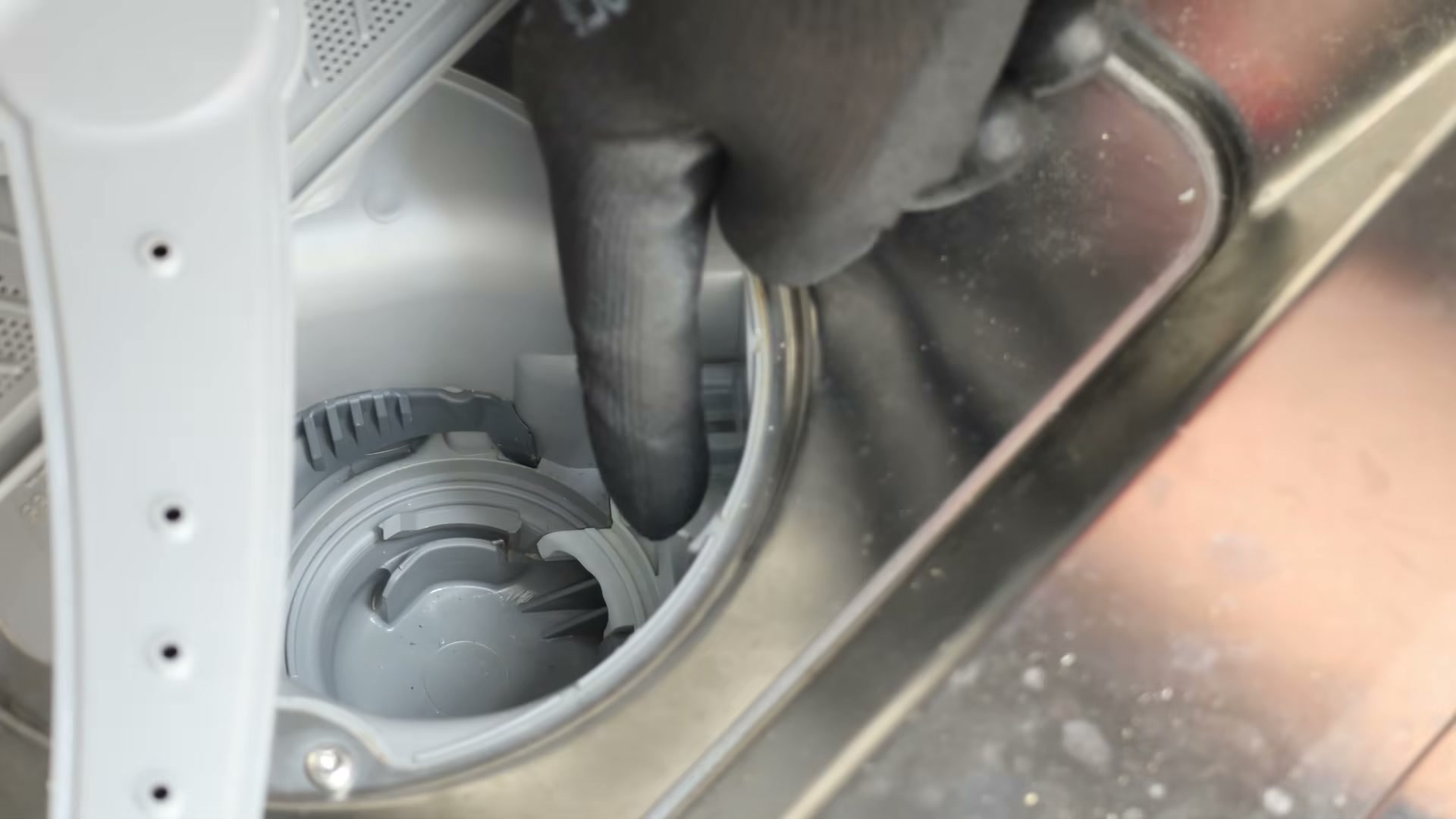 Unclipping the drain pump lid cover inside the drain pump housing
