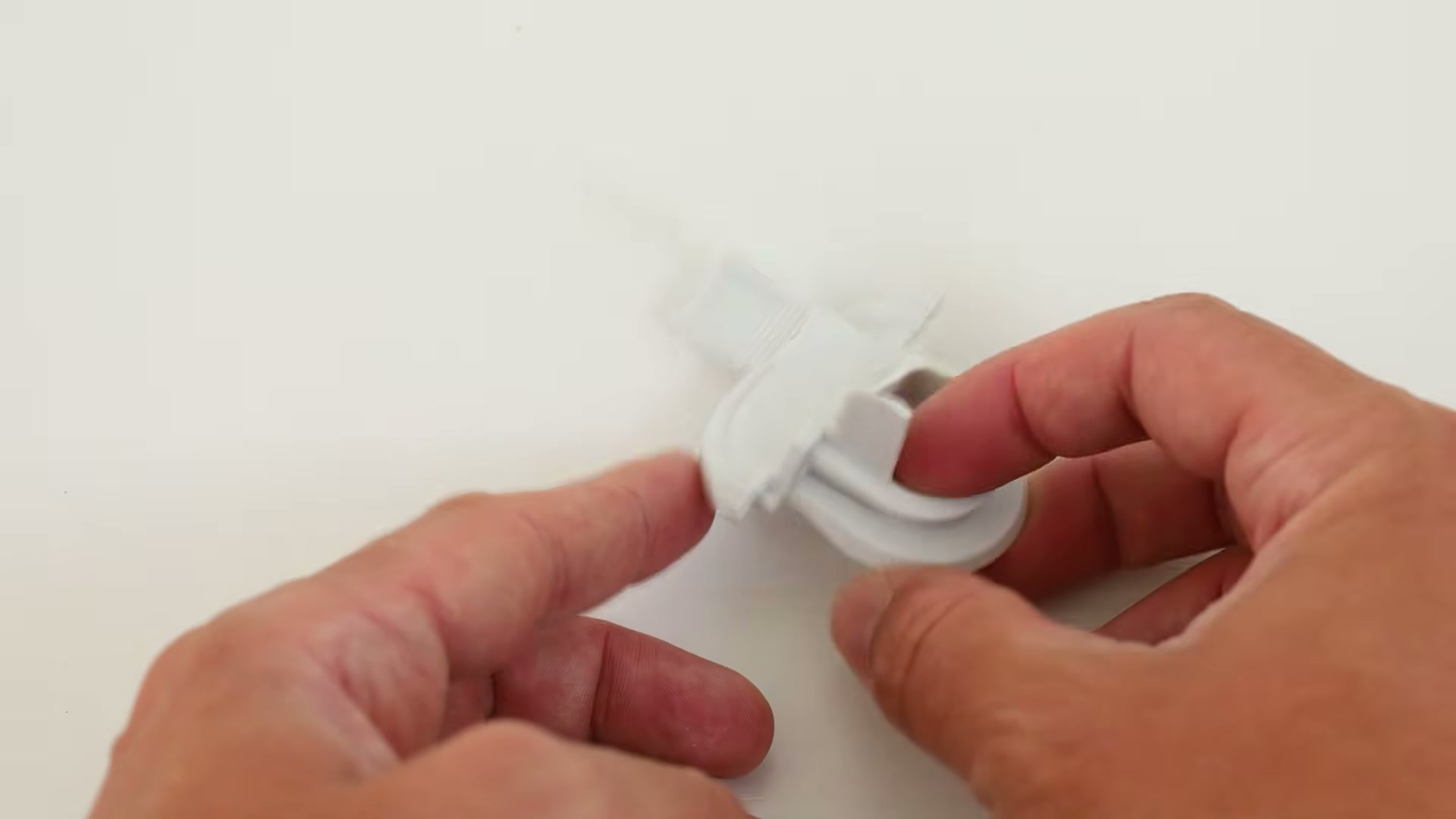 Holding the new white Bosch drain pump lid cover