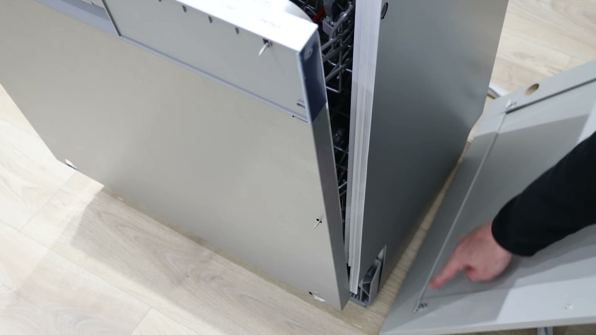 Integrated cabinet door being lined up with the fixing brackets on a Bosch dishwasher for refitting