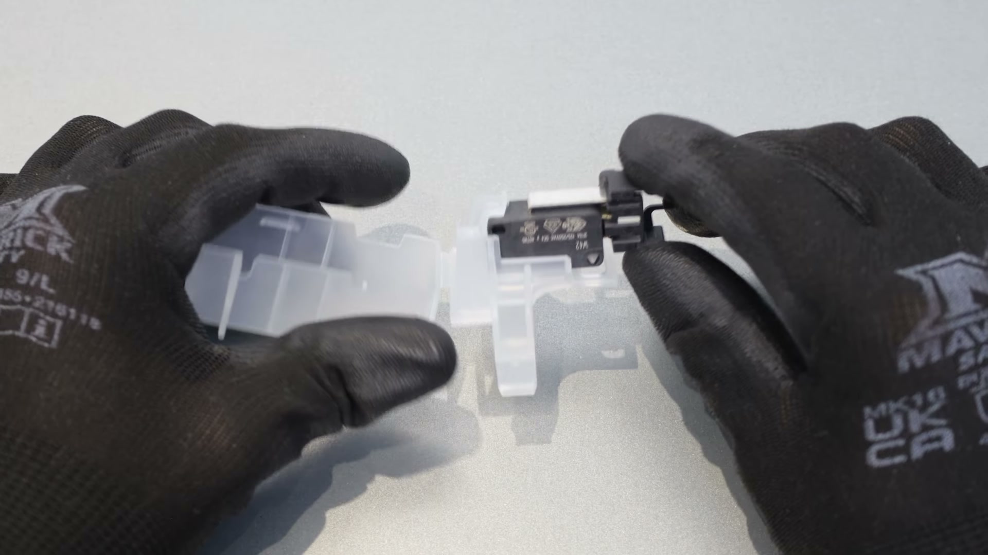 New Bosch dishwasher float switch held next to its plastic casing before assembly