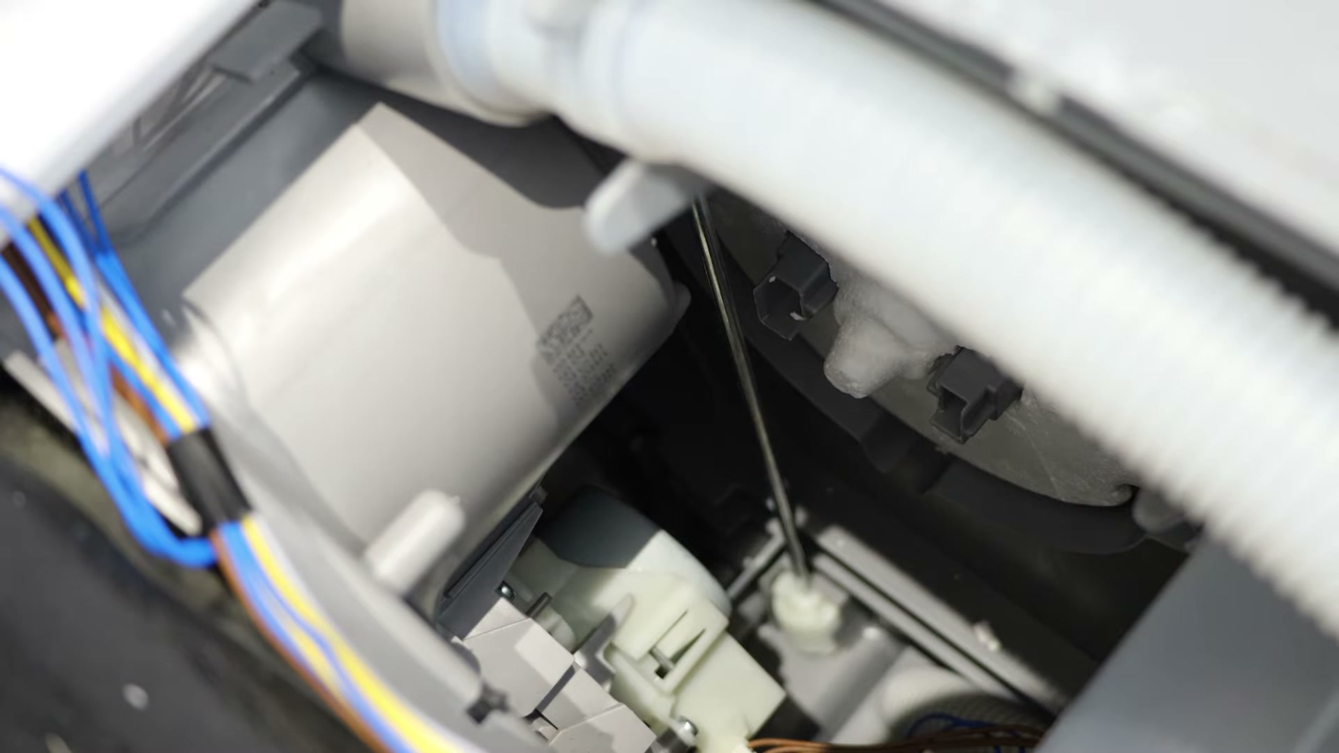 Fitting the new white polystyrene float into the base tray of a Bosch dishwasher