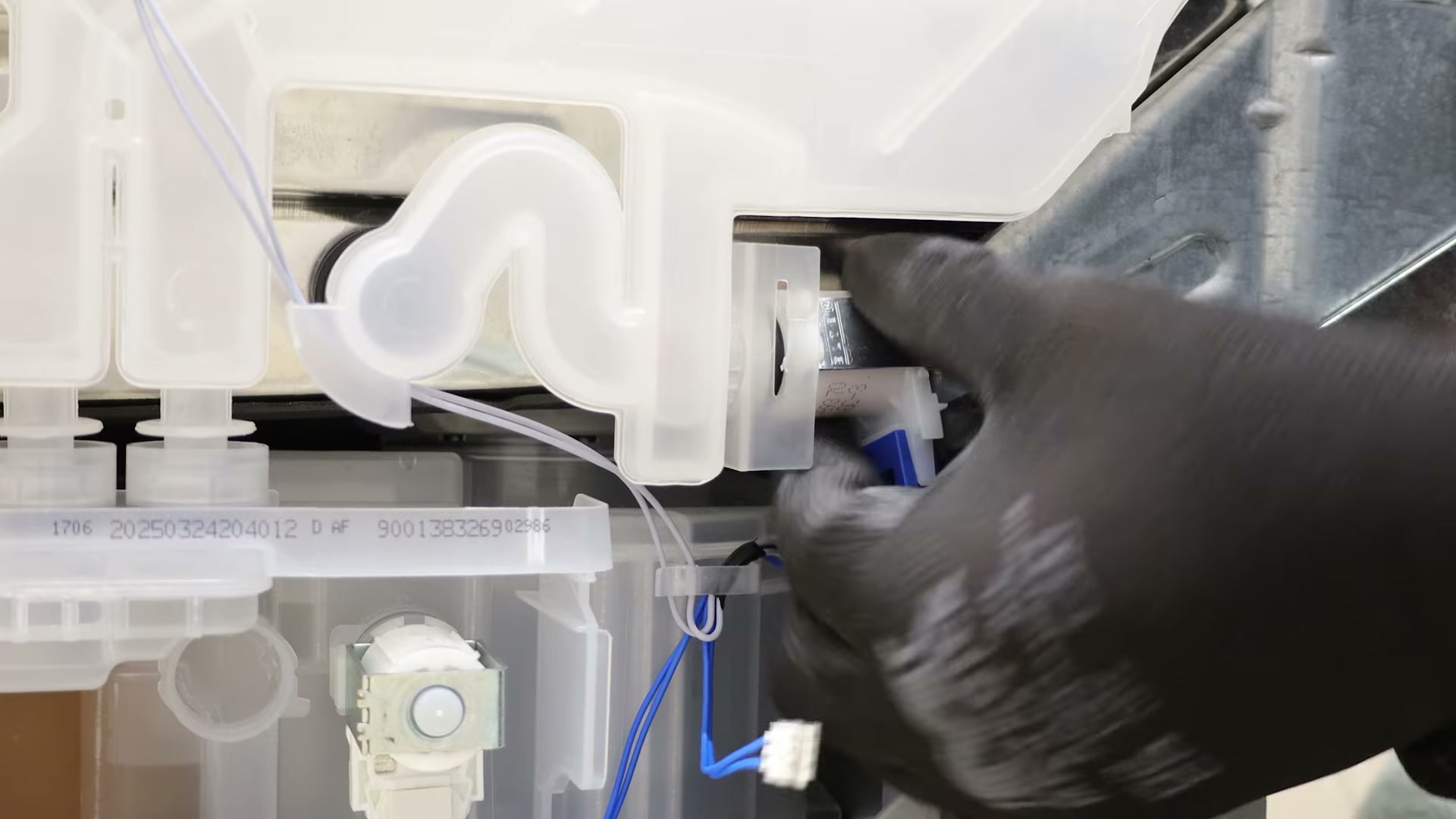 New heat exchanger outlet valve being rotated into place inside a Bosch dishwasher