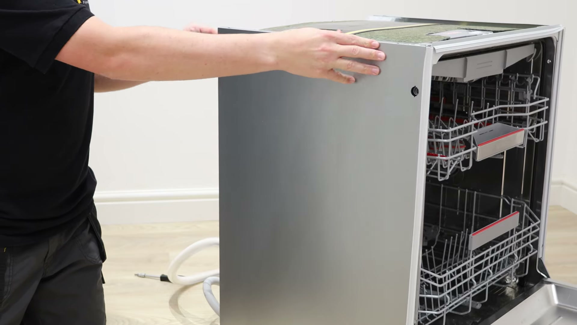 Left side panel being refitted onto a Bosch dishwasher after replacing the heat exchanger outlet valve