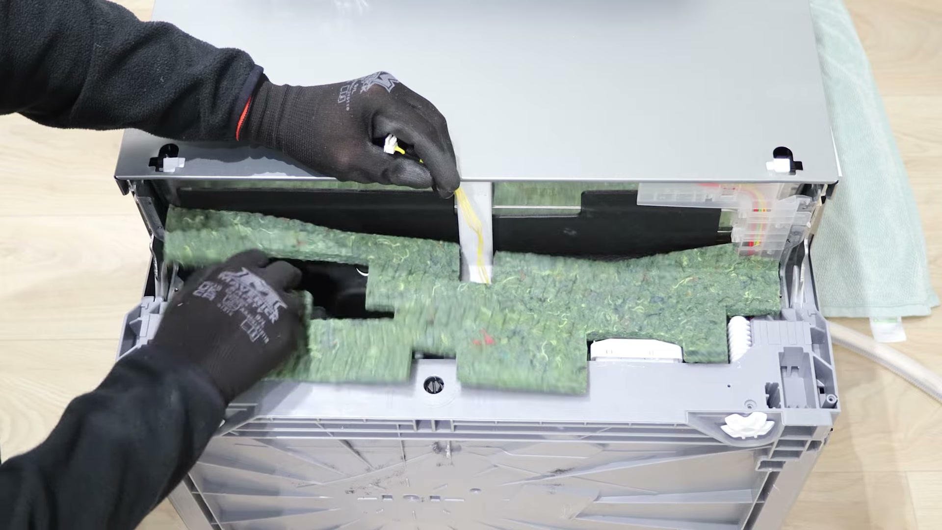 Fitting the new insulation plate behind the kick plate on a Bosch dishwasher