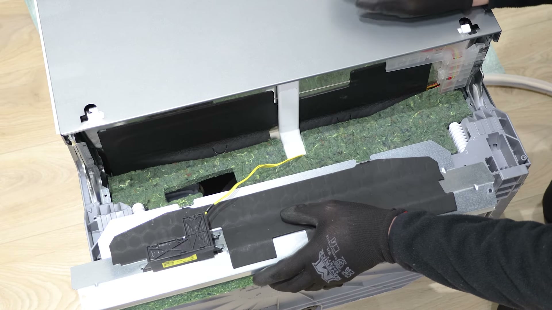 Kick plate removed from a Bosch dishwasher revealing the insulation plate behind