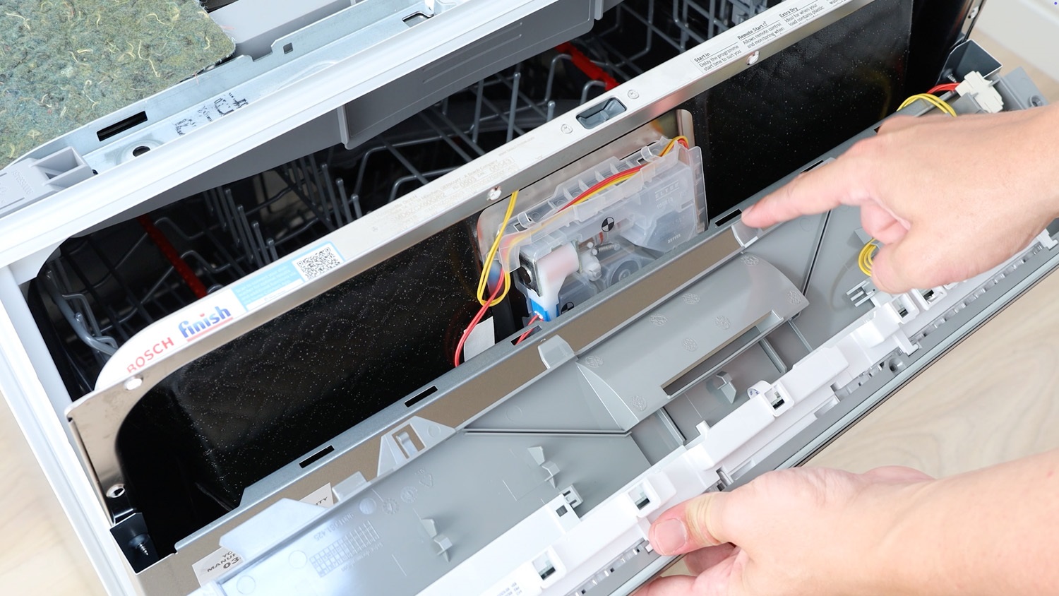 The tabs on the control panel slot into the door