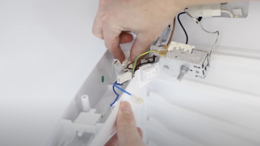 Attaching new light socket holder to the fridge freezer