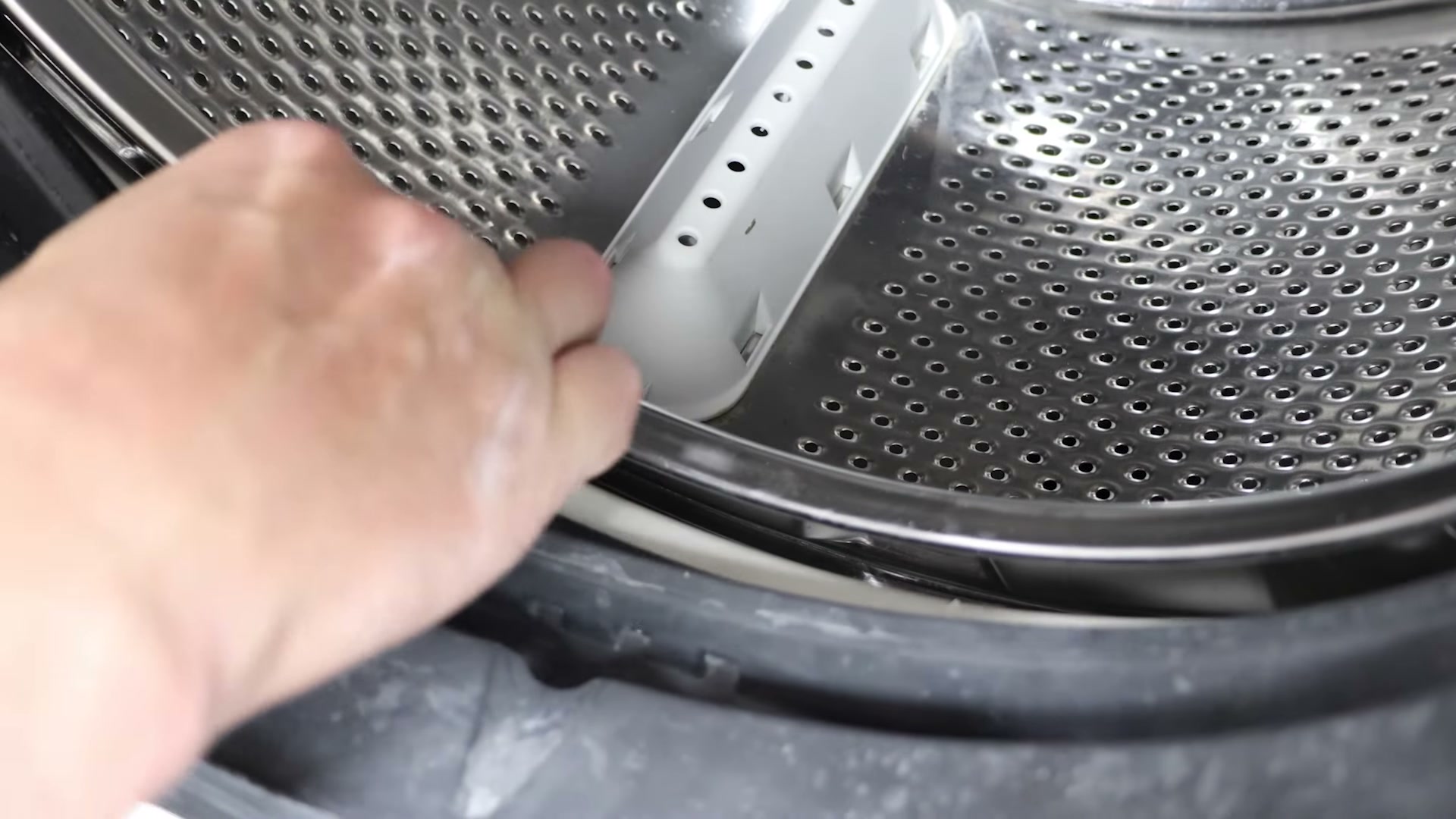 New door seal being pushed onto the drum lip inside a Hotpoint washing machine