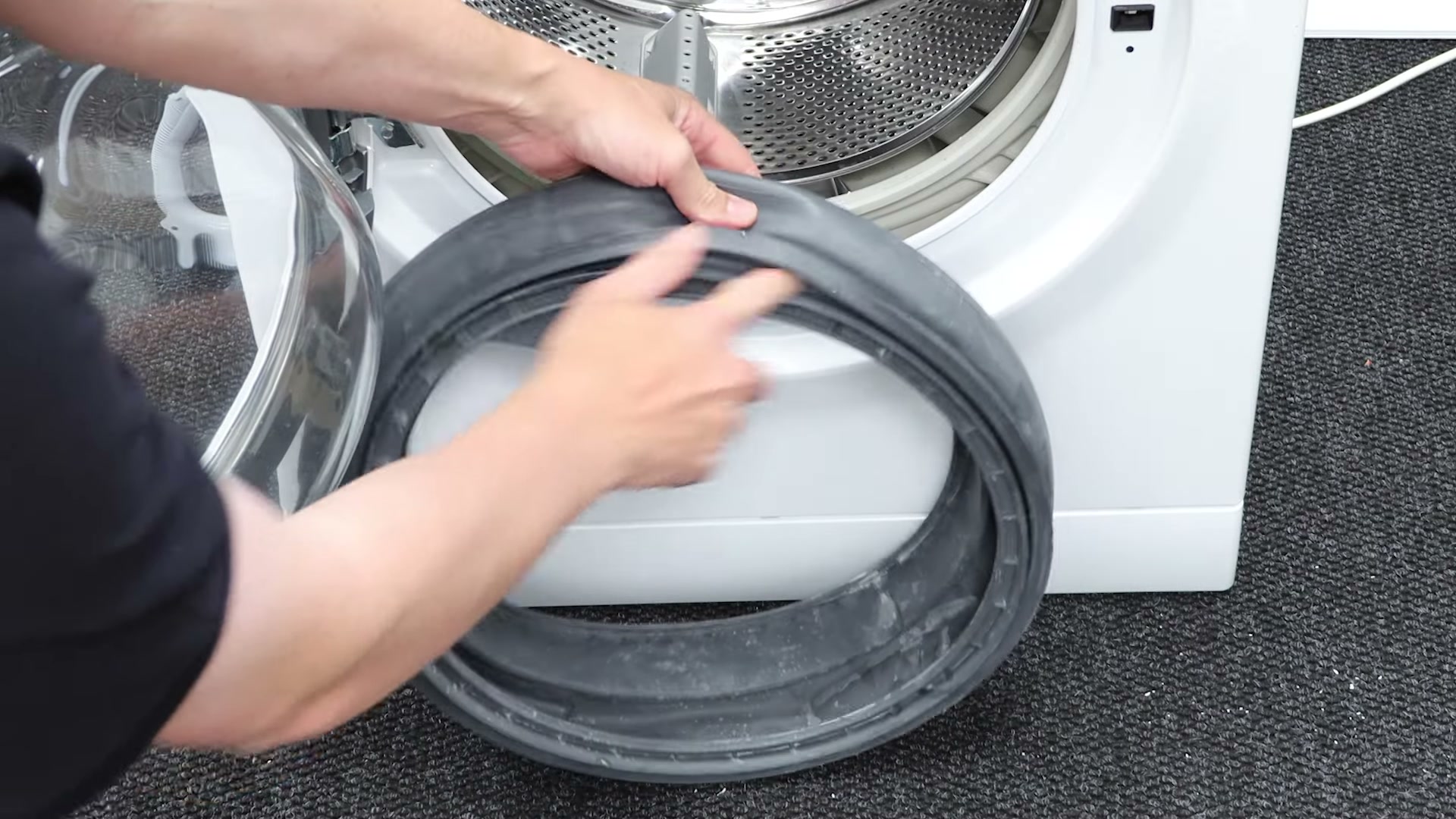 New Hotpoint washing machine door seal being lubricated with washing-up liquid