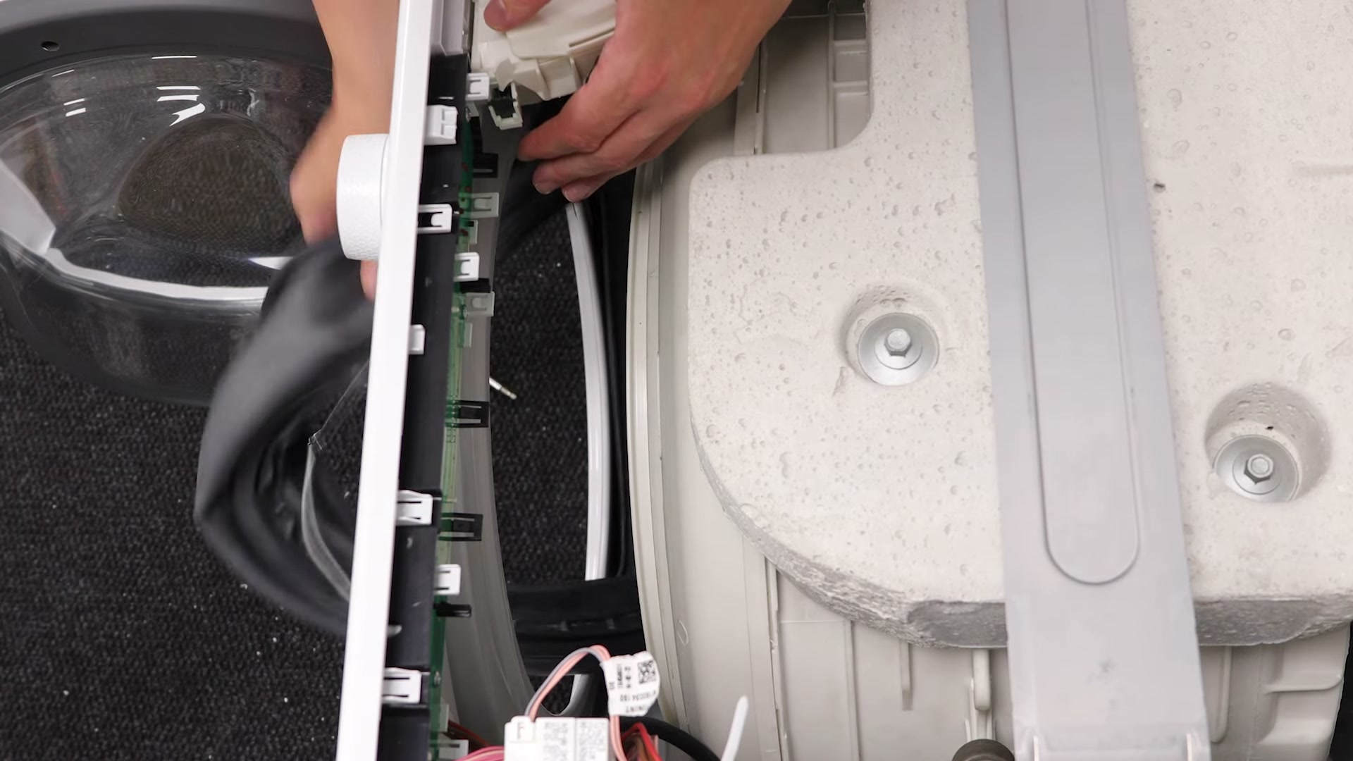Old door seal being peeled away from the drum on a Hotpoint washing machine