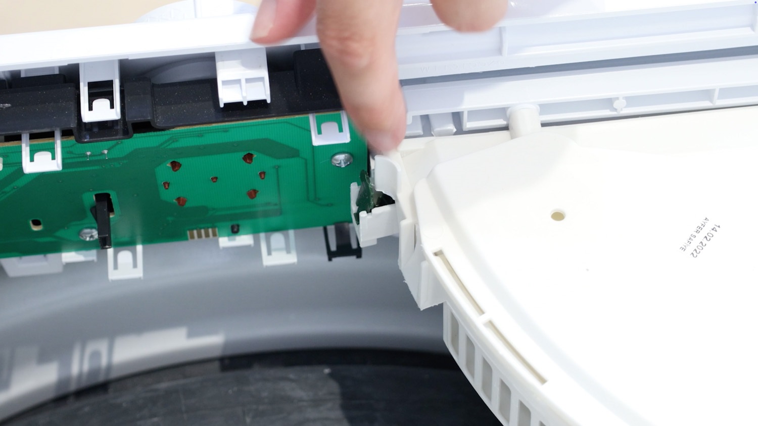 Place the new spring in the slot on the dispenser drawer