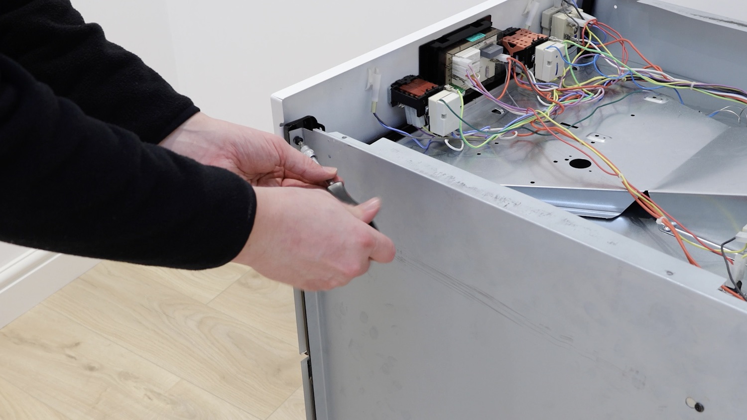 Remove screw holding side panel to control panel