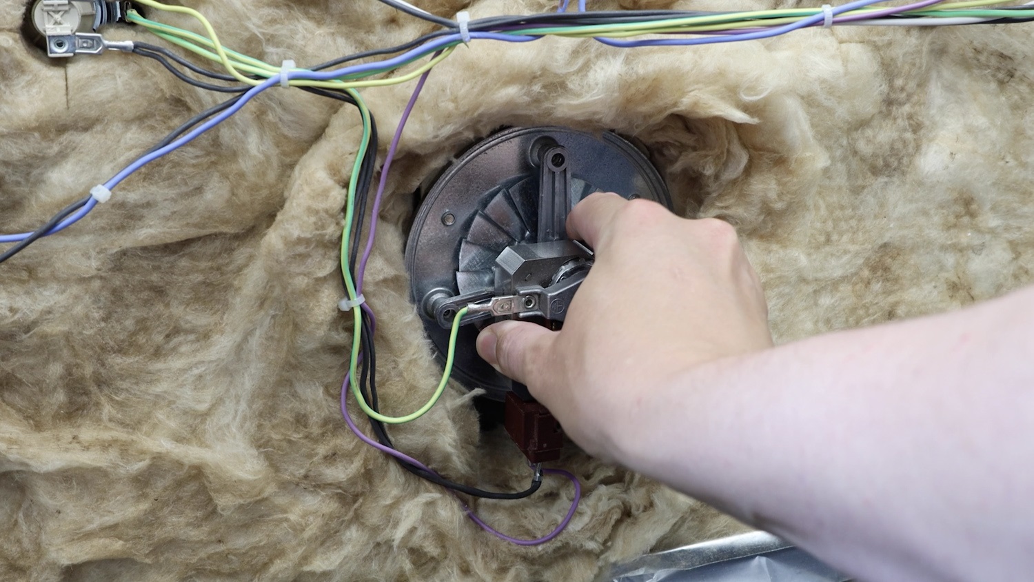 Pull oven fan motor down to secure in place