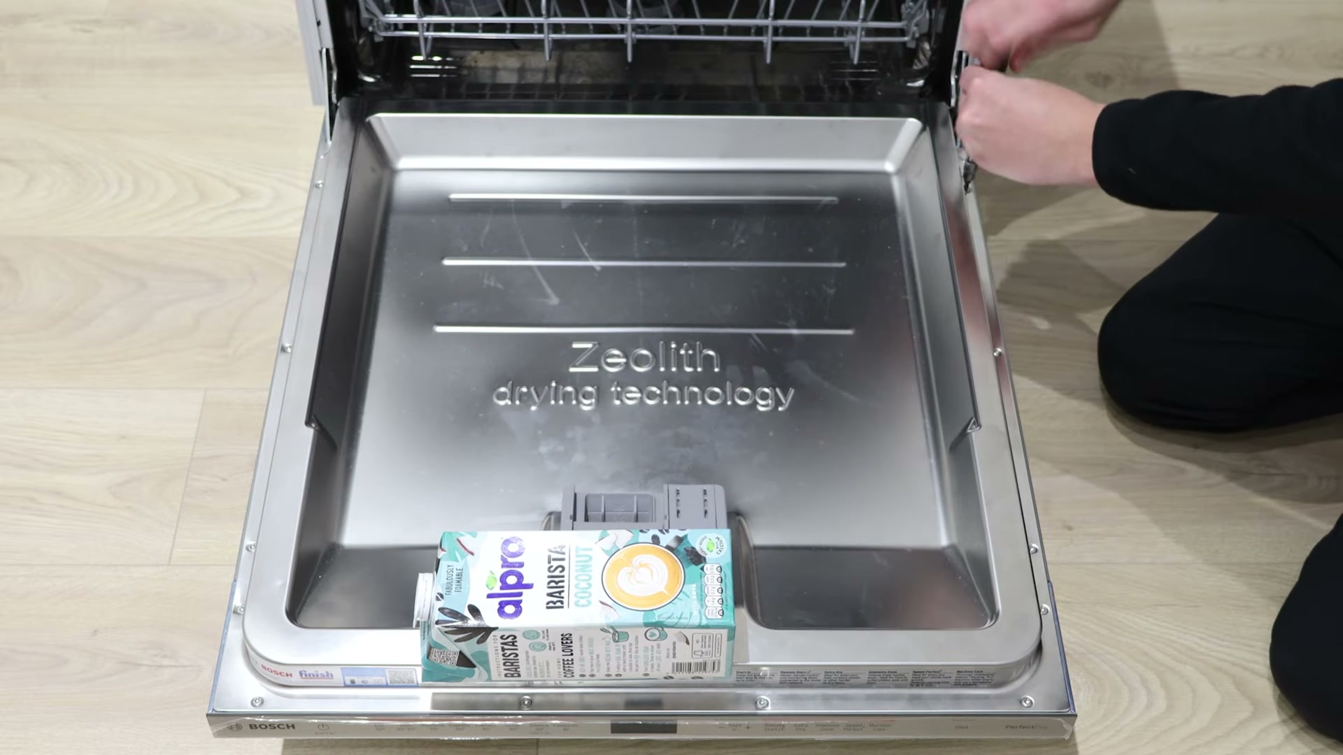 Milk carton weighing down a Bosch dishwasher door while removing the outer front panel screws