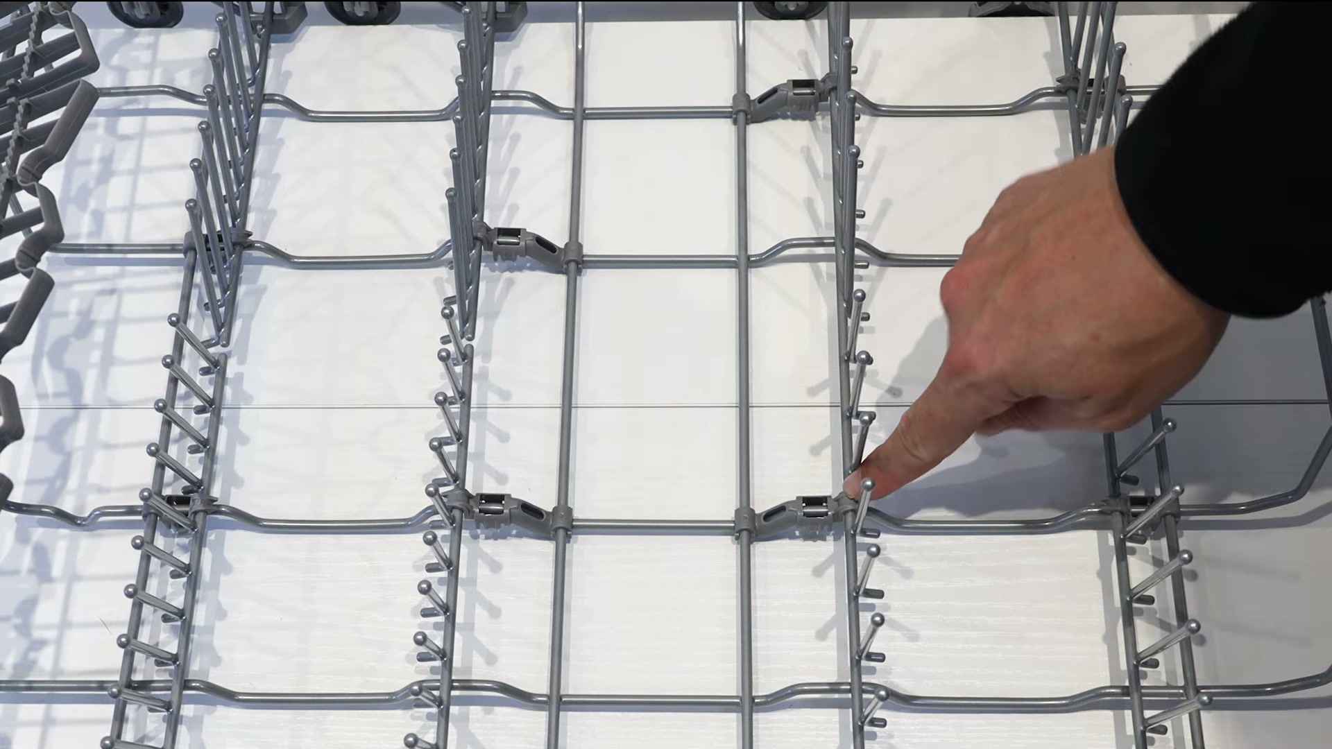 Locating the four central clips on the lower basket assembly of a Bosch dishwasher